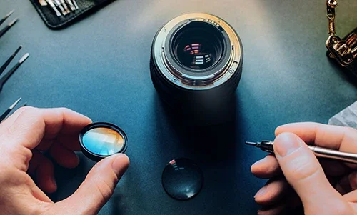 Camera lens repair with tools on desk