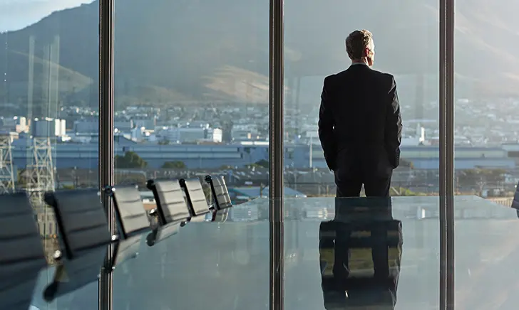 Businessman overlooking cityscape from boardroom