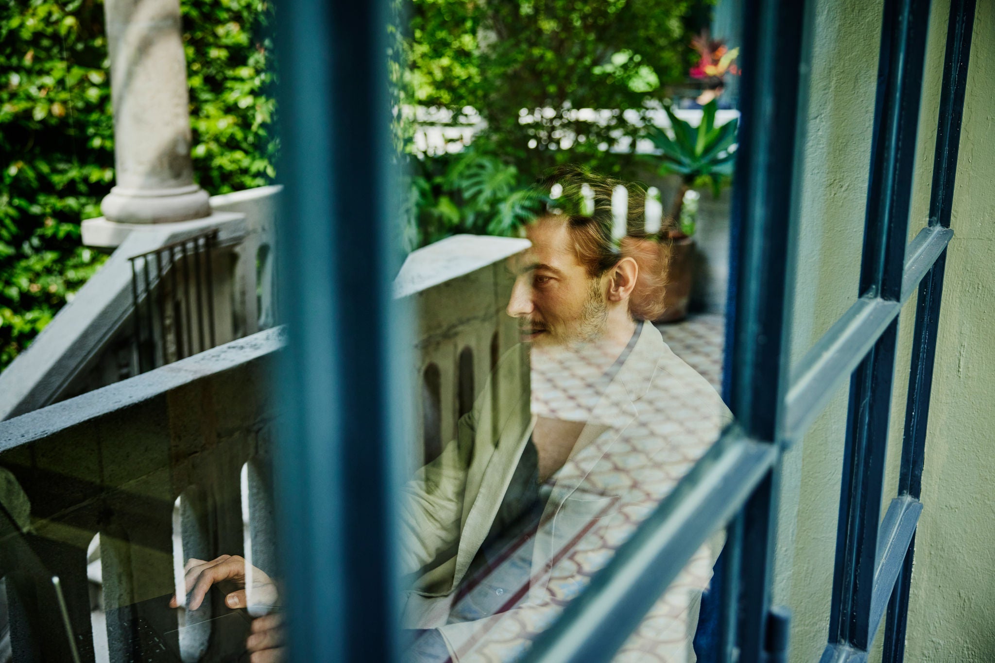 Person sitting on balcony with greenery
