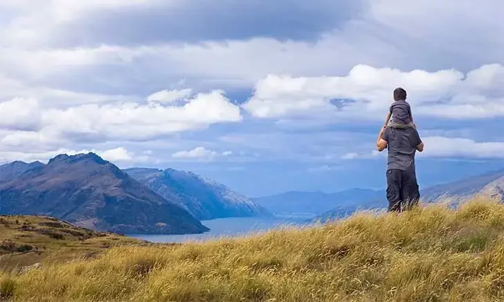 Father and child overlooking scenic mountains