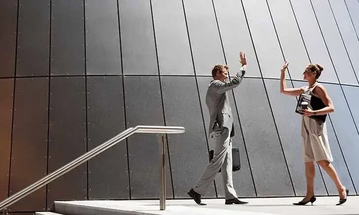 Business professionals high-five outdoors