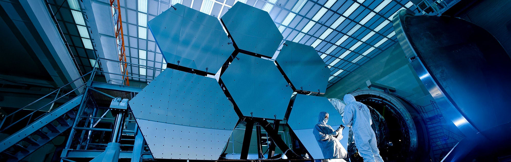 Scientists inspecting hexagonal mirror panels