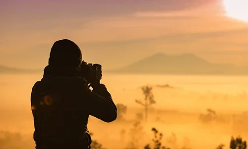 Silhouette of photographer capturing sunrise