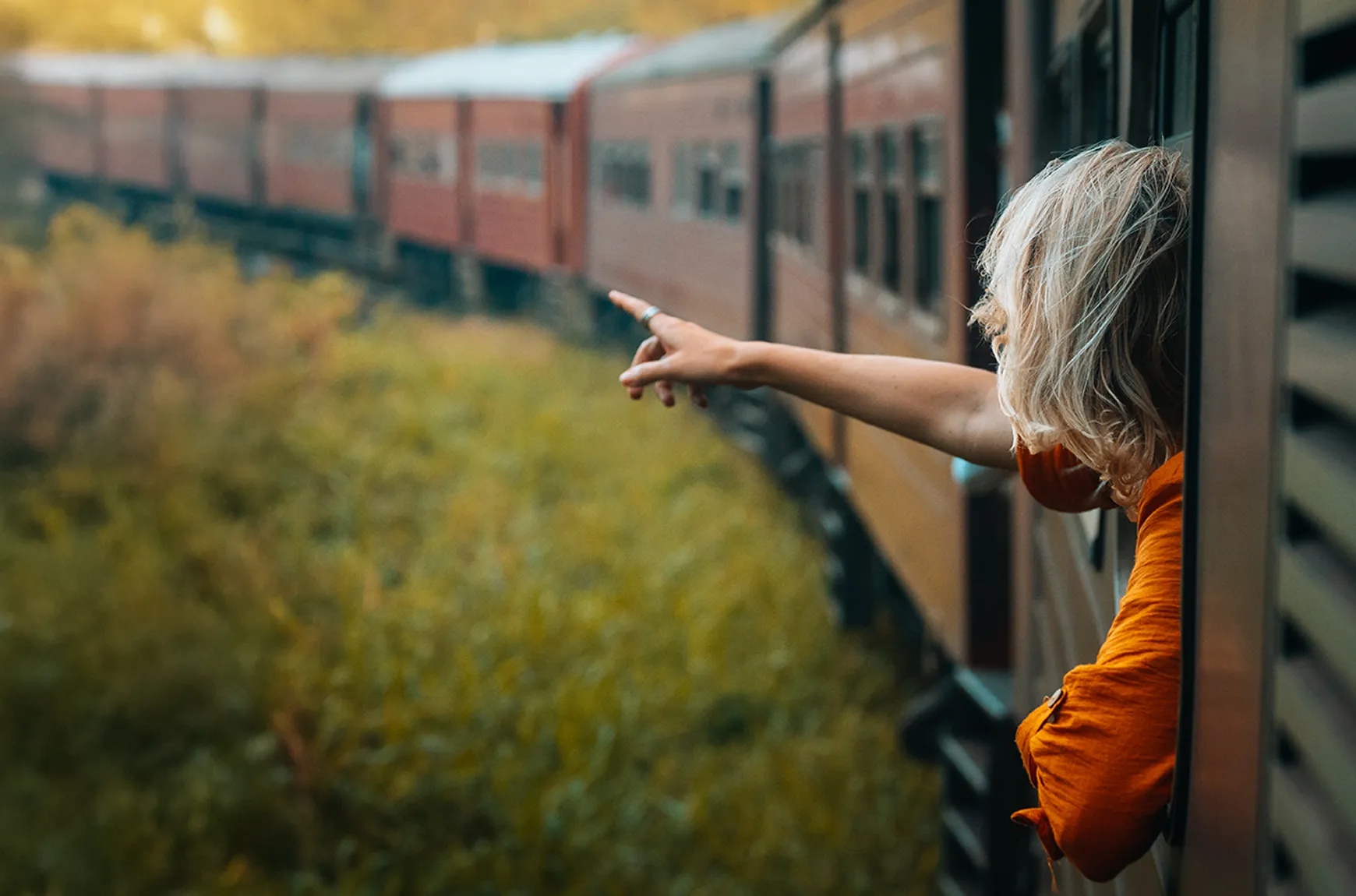Woman pointing out of a train