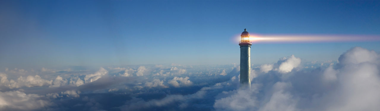 Lighthouse beacon shining through clouds